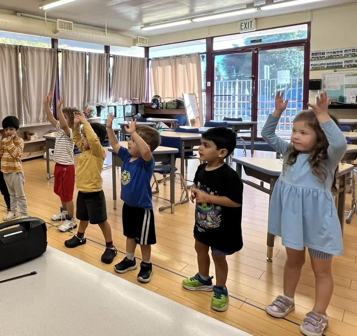 Children raising hands in a classroom activity.