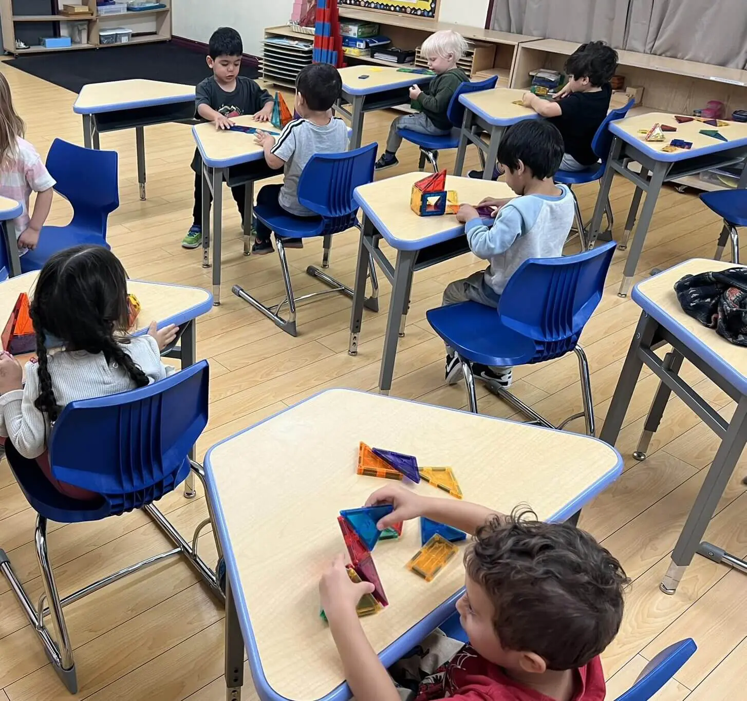 Children playing with colorful blocks in classroom.