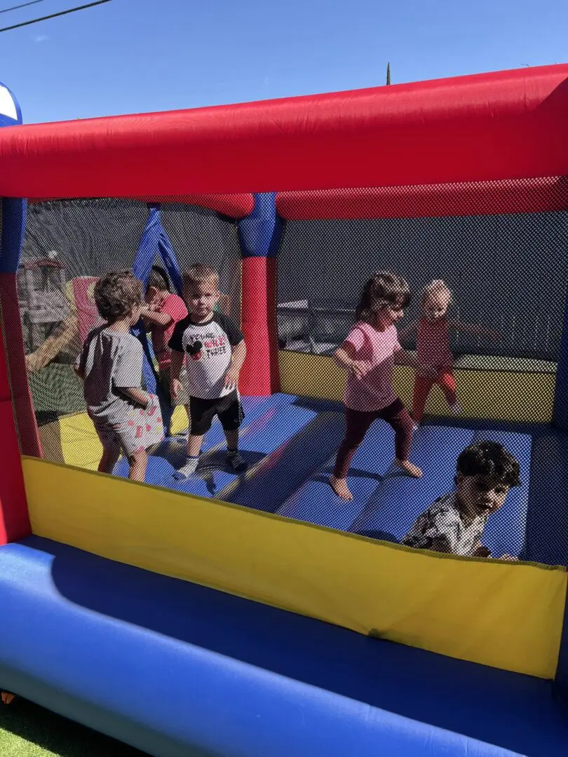 Children playing in a colorful bounce house.